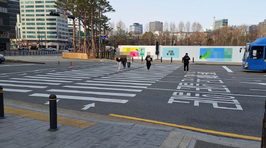 6일 오전 서울 중구 시청광장 앞에서 한 시민이 횡단보도를 스마트폰에 집중하며 횡단보도를 걷고 있다. <박상길 기자>